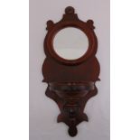 A mahogany wall bracket inset with circular mirror, 74.5 x 32cm