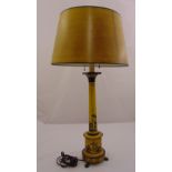 An Italian toile ware yellow lamp base of columnular form on cylindrical base with three paw feet to