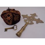 A religious hat with velvet and gold brocade decoration, a metal processional cross and a brass key