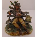 Capodimonte figurine of a gentleman of the road seated on a bench, signed to base, 23cm (h)