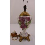 A French ceramic lamp base the ovoid body decorated with flowers and leaves on four gilded metal