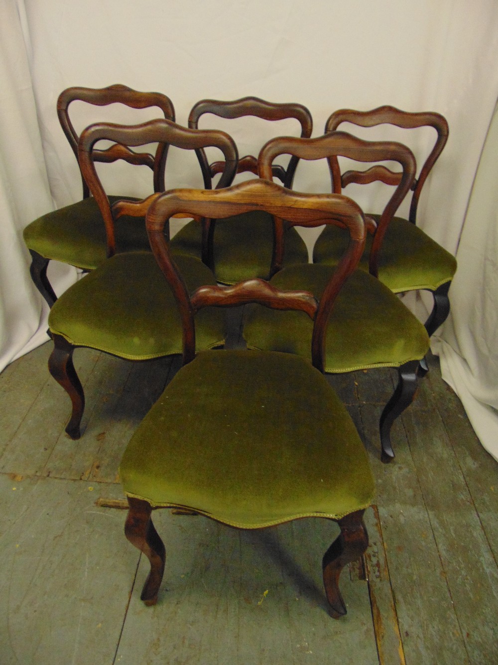 A set of six Victorian rosewood balloon back upholstered dining chairs on cabriole legs