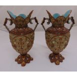 A pair of continental ceramic two handled vases decorated throughout with flowers and leaves on