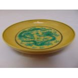 Chinese yellow ground plate decorated with dragons chasing a flaming pearl, Kangxi marks to the