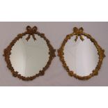 A pair of 19th century wall mirrors with ormolu frames of leaves and flowers surmounted by