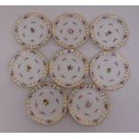 A set of eight continental fruit plates decorated with flowers and gilded borders