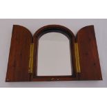 A mahogany wall mirror, arched top the hinged doors set with key hooks, 30 x 22cm