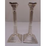 A pair of hallmarked silver Corinthian column table candlesticks with beaded borders on stepped