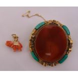 A coral and gold charm in the form of an elephant and a Scottish agate and malachite brooch