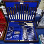 An Edwardian canteen of cutlery for 6 people, including carving set, by Walker & Hall, in fitted oak