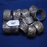 A set of 11 Indian metal napkin rings, with embossed dragon decoration
