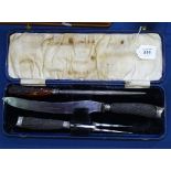 An Edwardian horn-handled "Silver Steel" cased carving set with silver collars, Sheffield 1905,