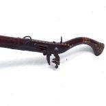 A Middle Eastern flintlock camel rifle, with brass strapwork and mother-of-pearl inlay, length 148cm