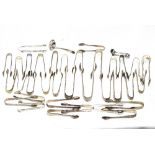 A collection of silver plated sugar nips and tongs