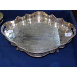 A silver plate on copper 2-handled tea tray of serpentine form, with raised pierced gallery, width