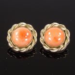 A pair of 9ct gold cabochon coral earrings, with clip fittings and rope twist surround, earring