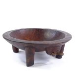 A large Ethnic hardwood food bowl on 4 legs, carved from a single piece of wood, diameter 38cm