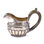 A 19th century Russian silver cream jug, of half fluted form with gadrooned border and a gilt