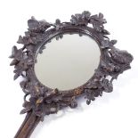 A 19th century Black Forest carved wood framed hand mirror, surrounded by birds and acorns, length
