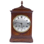 An oak-cased 8-day mantel clock, circa 1900, carved case with silvered dial and striking movement,