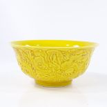 A Chinese yellow glaze porcelain bowl with relief moulded dragon designs, impressed seal mark,