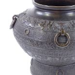 A Chinese patinated bronze jardiniere with neck ring handles and relief moulded bands, impressed