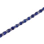 A sterling silver sapphire line bracelet, total oval-cut sapphire content approx 19ct, bracelet