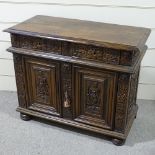 An 18th/19th century French oak side cupboard, with relief carved frieze drawers and fielded