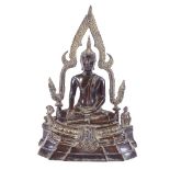 An Oriental patinated bronze seated Buddha with shaped canopy above, text inscription to reverse,