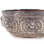 A small Burmese unmarked white metal Thabeik bowl, high relief figural and lotus decoration with