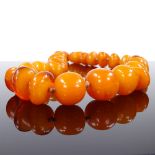 A simulated butterscotch amber single strand necklace, largest bead length 18.6mm, necklace length