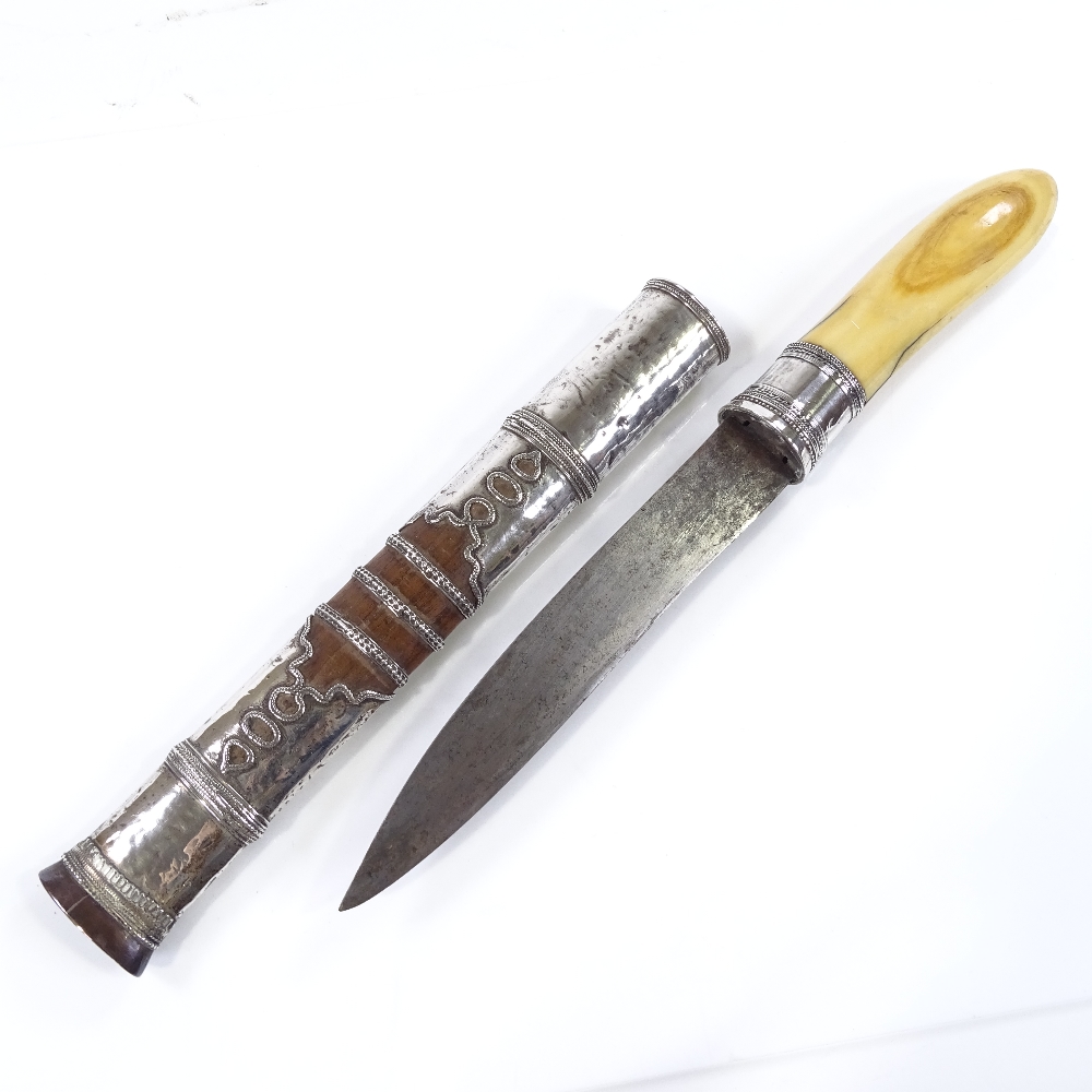 A Burmese silver-mounted dagger, circa 1900, with ivory hilt and original silver-mounted wood