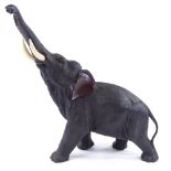 A Japanese patinated bronze elephant with rearing head and ivory tusks, Meiji Period, signed under