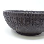 A Russian carved and stained wood bowl, with band of Cyrillic text to the frieze and central