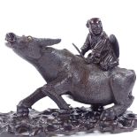 A finely carved Oriental hardwood figure of a boy riding a water buffalo, on original carved and