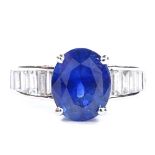 An unmarked white gold sapphire and baguette-cut diamond ring, oval-cut sapphire approx 4ct, total