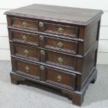 An 18th century joined oak chest of 4 long drawers, with panelled drawer fronts and bracket feet,