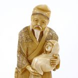 A Japanese 2-tone stained ivory okimono, man carrying an infant, Meiji period, signed under base,