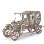 A Maltese unmarked silver filigree Veteran car model, rotating wheels and hinged cab doors, length