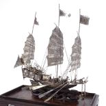 A Chinese silver model junk boat, cannons and moving oars, marked on back of boat and on middle