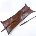 An African leather-fronted Tribal shield, panel height 89cm, and a steel-tipped spear