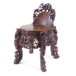 A 19th century Burmese hardwood chair, allover carved and pierced decoration with lion masks and