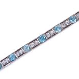 An Art Deco unmarked silver blue topaz and white sapphire line panel bracelet, openwork settings