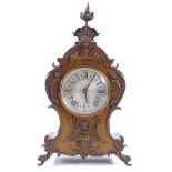 A late 19th century mantel clock with allover ornate cast-brass moulding and mounts, engraved
