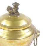 A Chinese polished bronze bowl and cover with lion ring handles, surmounted by a Dog of Fo, height