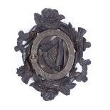 A Victorian carved bog oak Unity badge, with silver mount and shamrock rose and thistle designs,