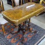 A 19th century burr-walnut foldover card table, raised on a quadruple column support and sabre