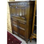 A modern oak cocktail cabinet, with a linenfold panelled fall-front, drawers under, on stile legs,