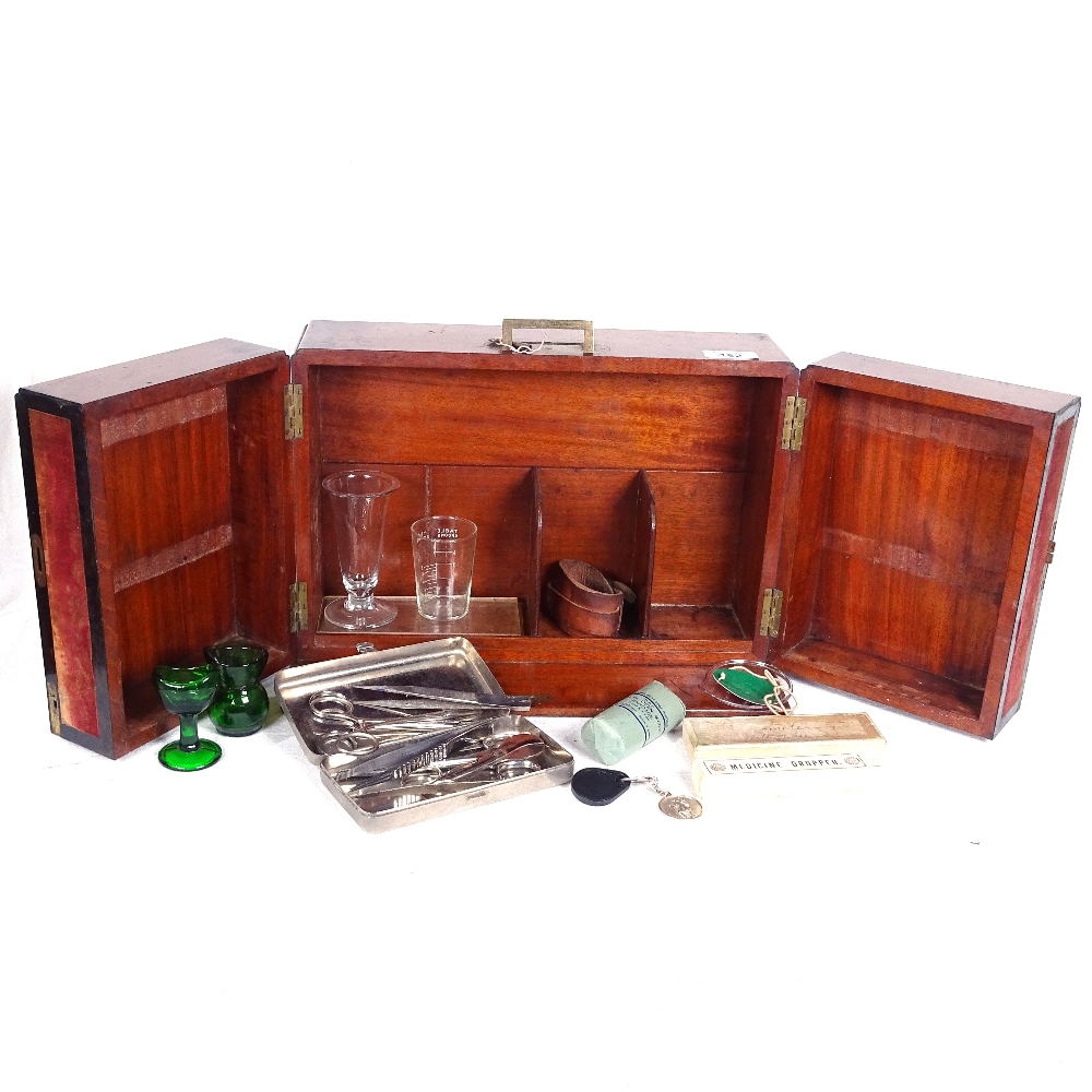 A 19th century mahogany medicine cabinet, with nickel-cased instruments, glass eye baths...