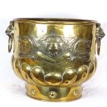 A large Victorian brass coal bucket, with relief embossed heraldic decoration and lion mask handles,